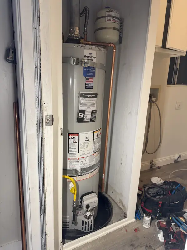 Newly installed tank water heater in a home's water heater closet